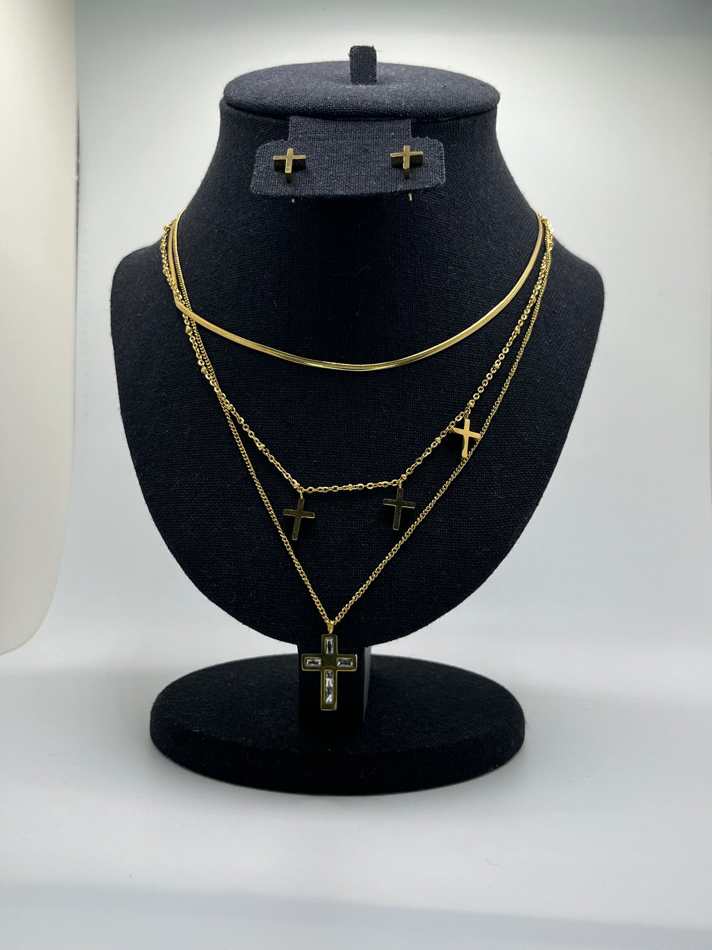 Black headband with gold chain design on a mannequin head against a white background